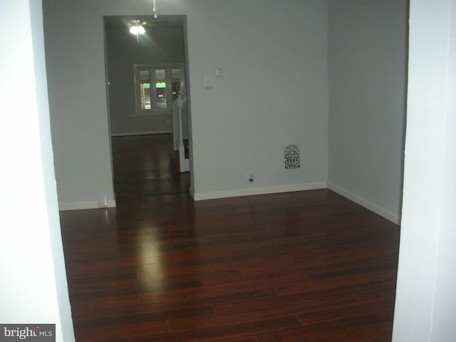 empty room featuring dark wood-style floors and baseboards