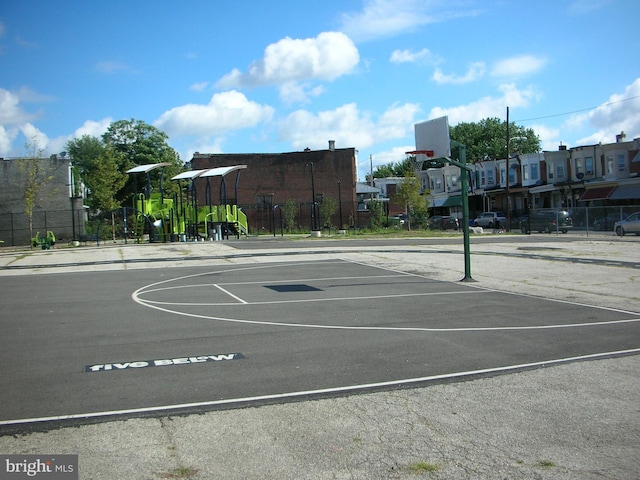 view of basketball court featuring playground community, fence, and community basketball court