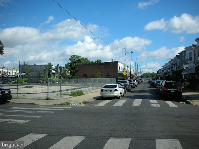 view of street featuring street lighting, traffic signs, and sidewalks