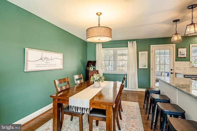 dining space featuring baseboards and dark wood finished floors