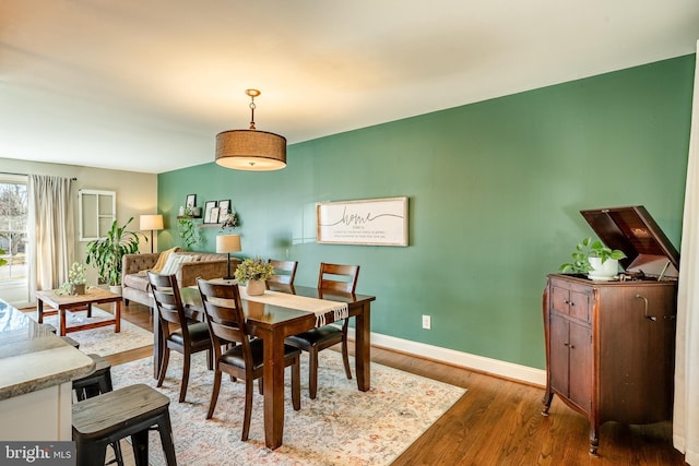 dining room featuring wood finished floors and baseboards