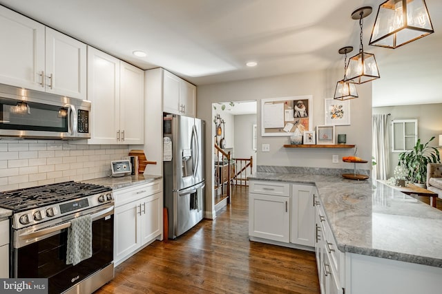 kitchen with dark wood-type flooring, decorative backsplash, a peninsula, stainless steel appliances, and white cabinetry