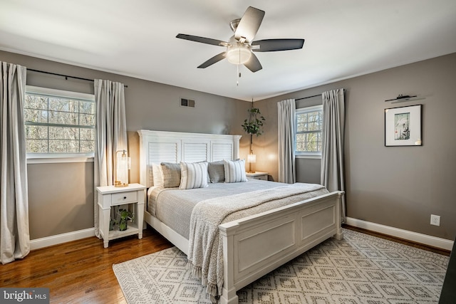 bedroom with visible vents, baseboards, ceiling fan, and light wood finished floors