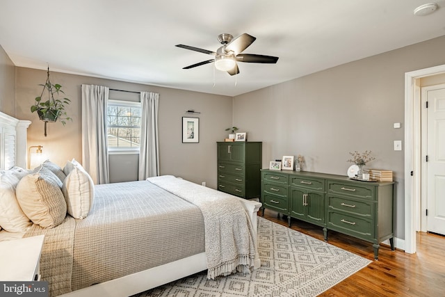 bedroom featuring dark wood finished floors, baseboards, and a ceiling fan