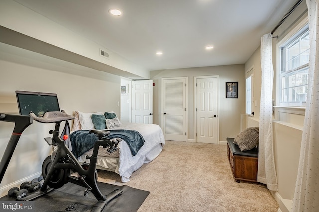 bedroom featuring carpet, visible vents, baseboards, recessed lighting, and two closets