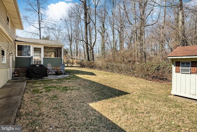 view of yard with a patio, fence, an outdoor structure, and a sunroom