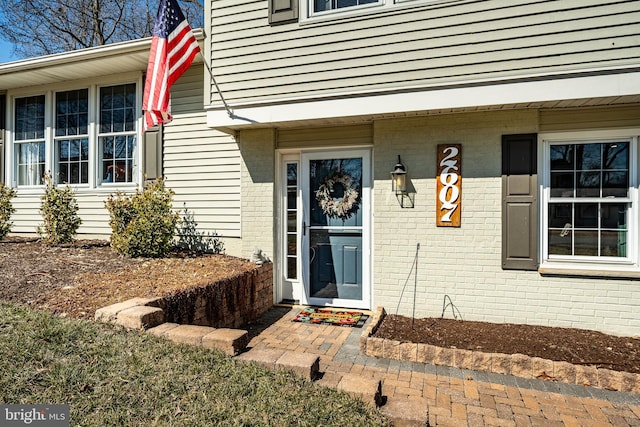 entrance to property featuring brick siding