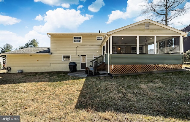 back of property with a patio area, a yard, and a sunroom