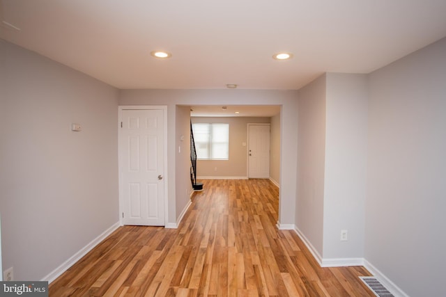 corridor featuring baseboards, recessed lighting, visible vents, and light wood-style floors