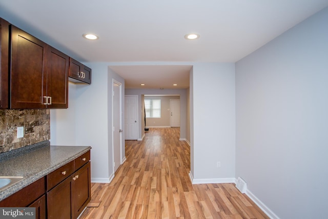 kitchen with dark brown cabinetry, recessed lighting, baseboards, light wood-style floors, and decorative backsplash