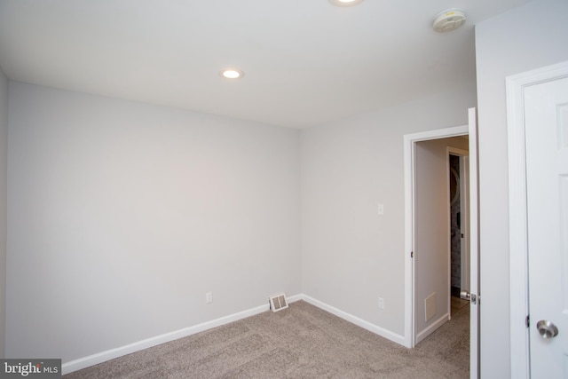 carpeted empty room featuring baseboards, visible vents, and recessed lighting