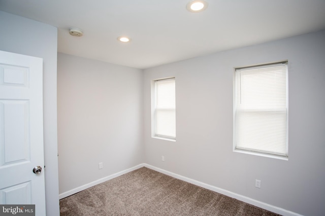 carpeted empty room featuring recessed lighting and baseboards