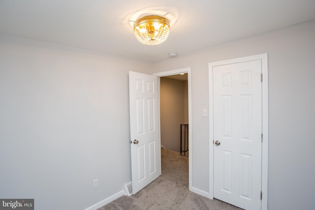 unfurnished bedroom featuring baseboards and light colored carpet