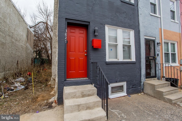 entrance to property featuring brick siding