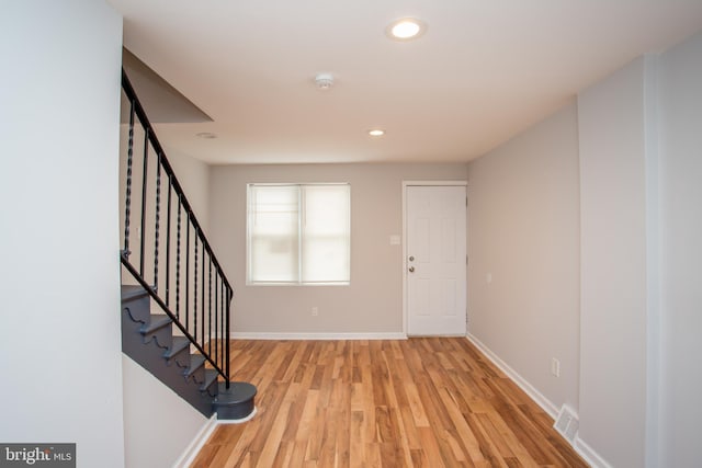 entryway featuring stairs, light wood-style flooring, visible vents, and baseboards