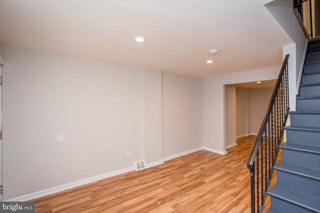 basement with light wood-style flooring, recessed lighting, visible vents, baseboards, and stairway