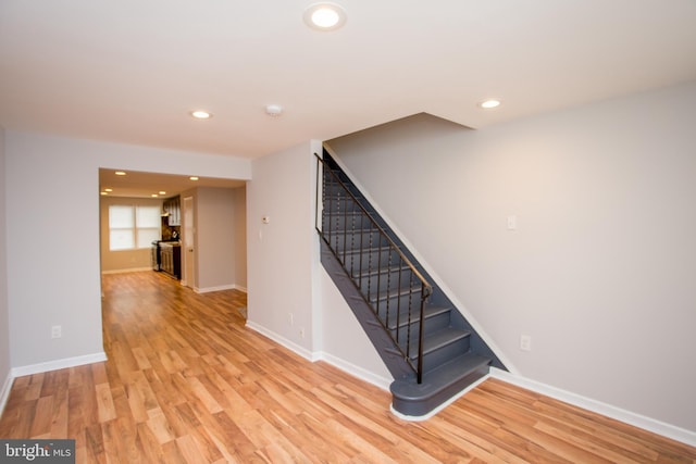 stairs with baseboards, wood finished floors, and recessed lighting