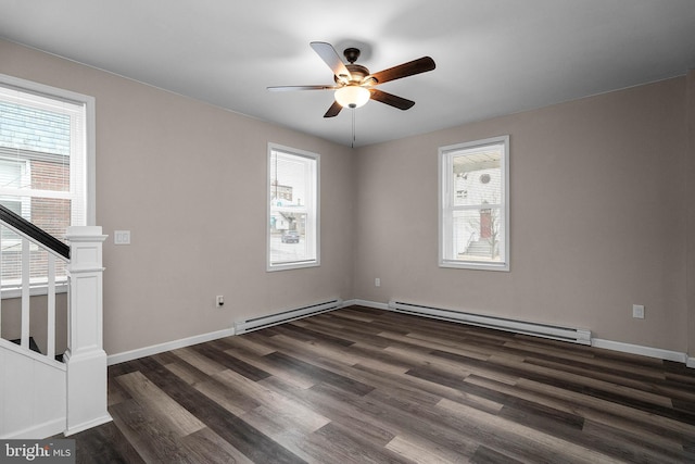 empty room with dark wood-type flooring, a baseboard radiator, stairway, and baseboards