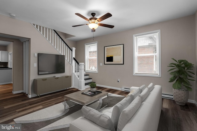 living area featuring dark wood-style flooring, baseboards, stairway, and baseboard heating