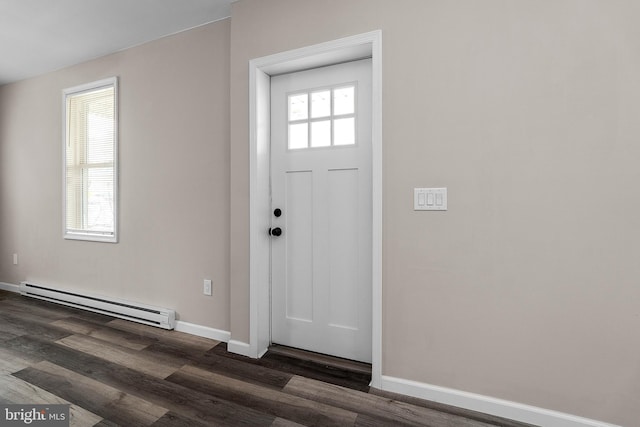 entrance foyer featuring a baseboard heating unit, dark wood finished floors, a wealth of natural light, and baseboards