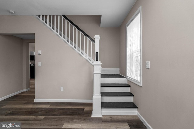 stairway featuring baseboards and wood finished floors