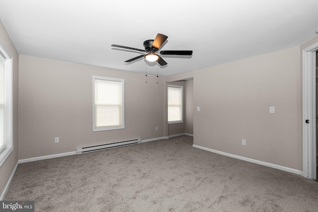 carpeted spare room with a baseboard radiator, a ceiling fan, and baseboards