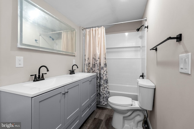 full bath with double vanity, wood finished floors, a sink, and toilet