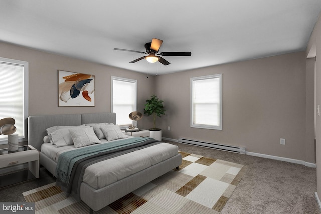 bedroom with a baseboard heating unit, carpet flooring, baseboards, and multiple windows