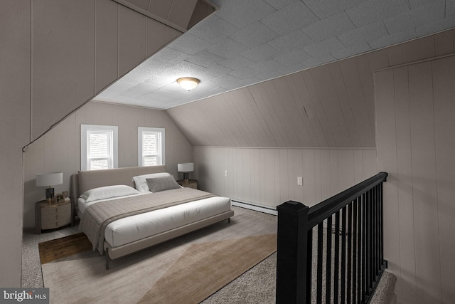 carpeted bedroom with lofted ceiling and a baseboard radiator