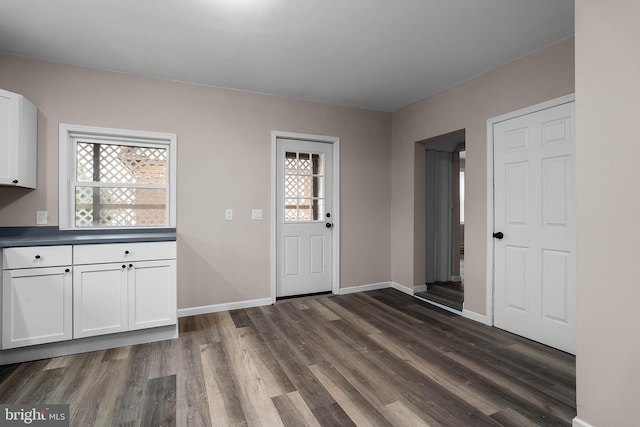 entryway with dark wood finished floors and baseboards