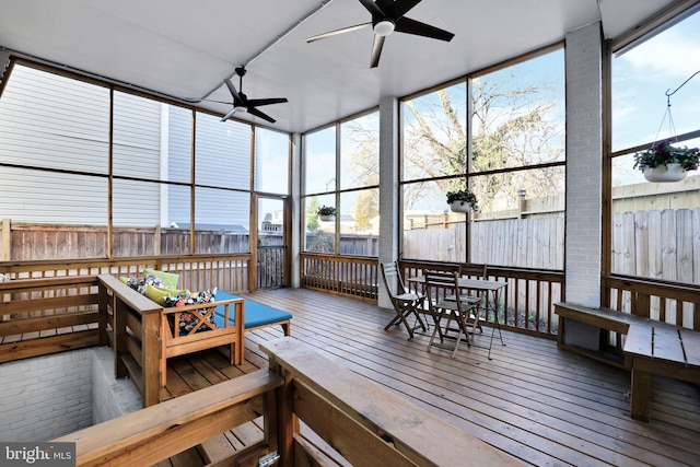 sunroom / solarium featuring a ceiling fan and plenty of natural light