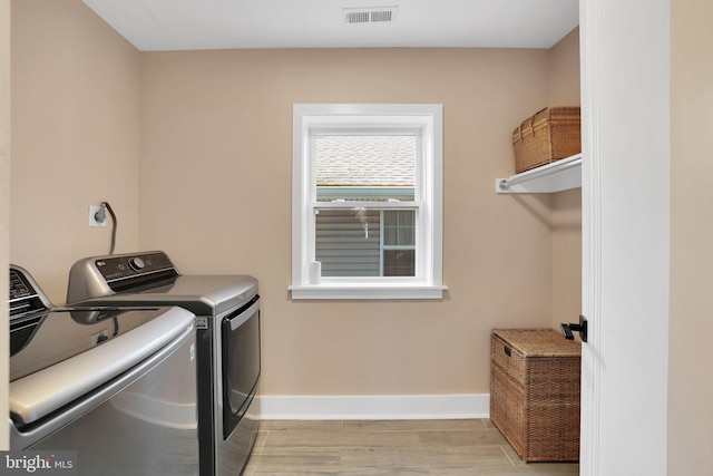 laundry area featuring separate washer and dryer, light wood-style flooring, laundry area, baseboards, and visible vents