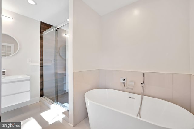full bath with a shower stall, recessed lighting, a freestanding tub, and vanity