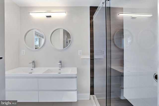 bathroom with double vanity, a sink, and a shower with door