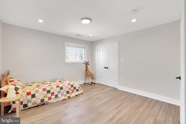 bedroom featuring recessed lighting, baseboards, visible vents, light wood-style flooring, and a closet