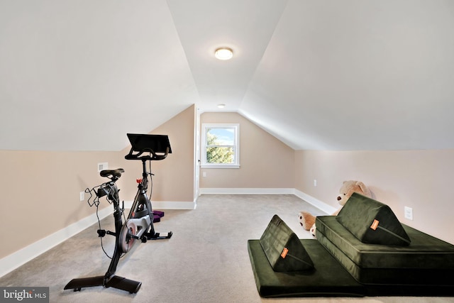 workout room with carpet flooring, baseboards, and vaulted ceiling