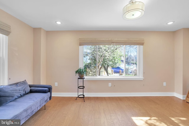 living area with baseboards, light wood-style floors, and recessed lighting