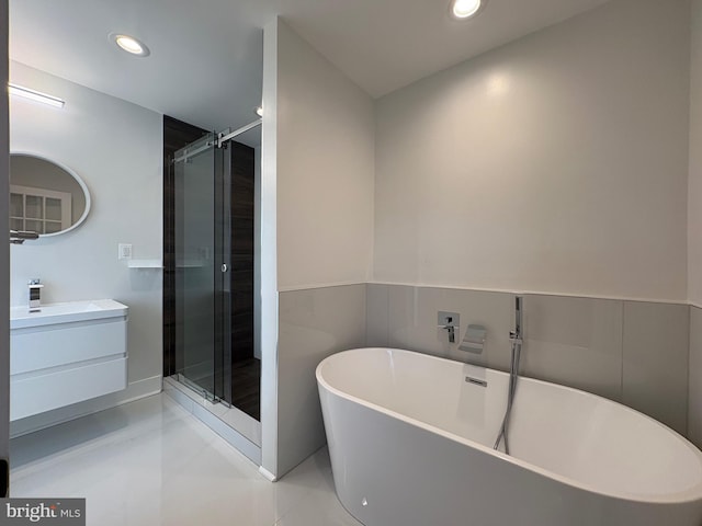 full bathroom with a freestanding bath, vanity, recessed lighting, and a shower stall
