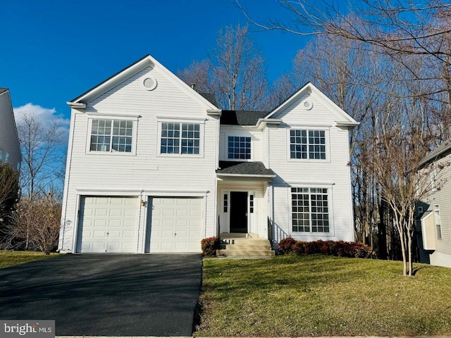 traditional-style house featuring driveway, a front yard, and a garage