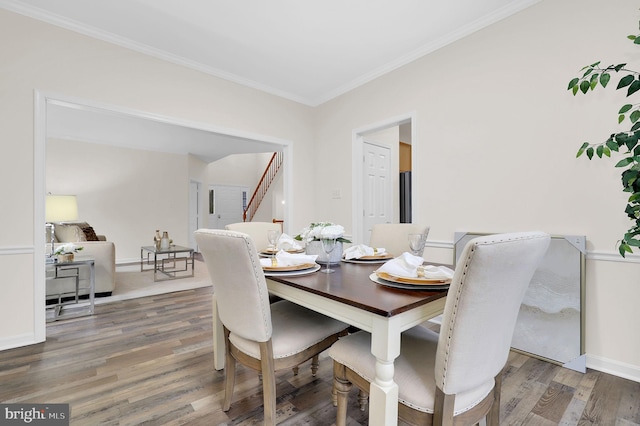 dining area with stairway, baseboards, wood finished floors, and ornamental molding