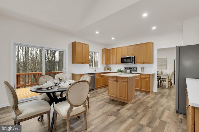 kitchen featuring a center island, light wood-type flooring, light countertops, recessed lighting, and appliances with stainless steel finishes