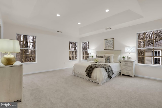 carpeted bedroom with recessed lighting, baseboards, a raised ceiling, and visible vents