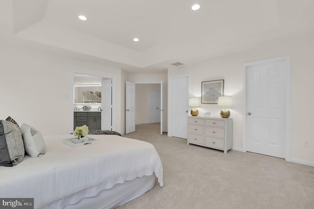 bedroom with visible vents, baseboards, light colored carpet, a tray ceiling, and recessed lighting