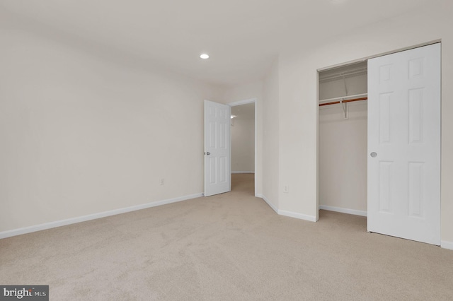 unfurnished bedroom with recessed lighting, a closet, baseboards, and carpet