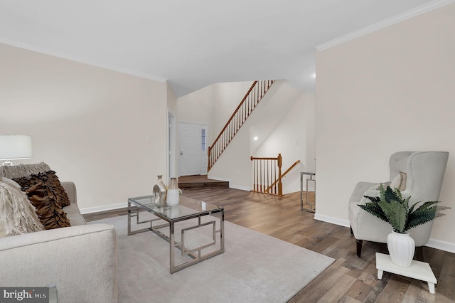 living area with wood finished floors, baseboards, and ornamental molding