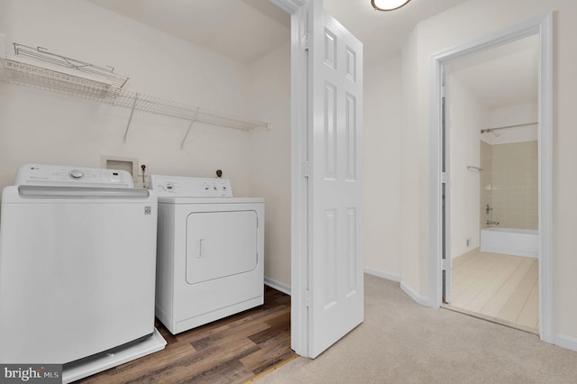 laundry area featuring wood finished floors, baseboards, and washer and clothes dryer