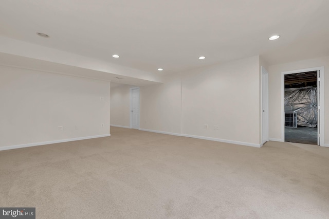 unfurnished room with recessed lighting, baseboards, and light carpet