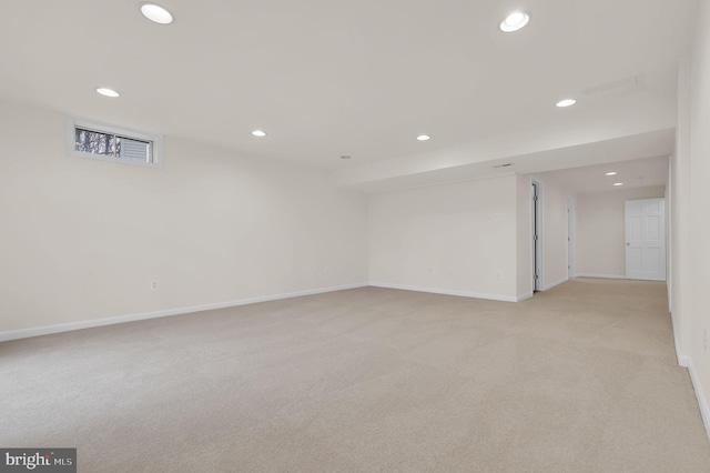 empty room featuring recessed lighting, baseboards, and light carpet