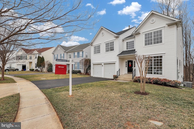 traditional home featuring a front yard, driveway, central AC, a garage, and a residential view