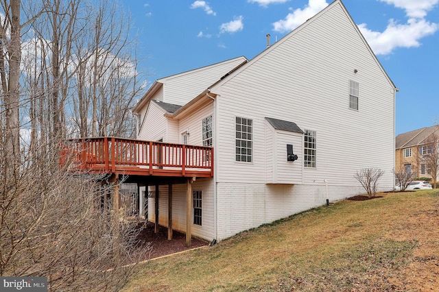 view of side of home featuring a yard and a wooden deck